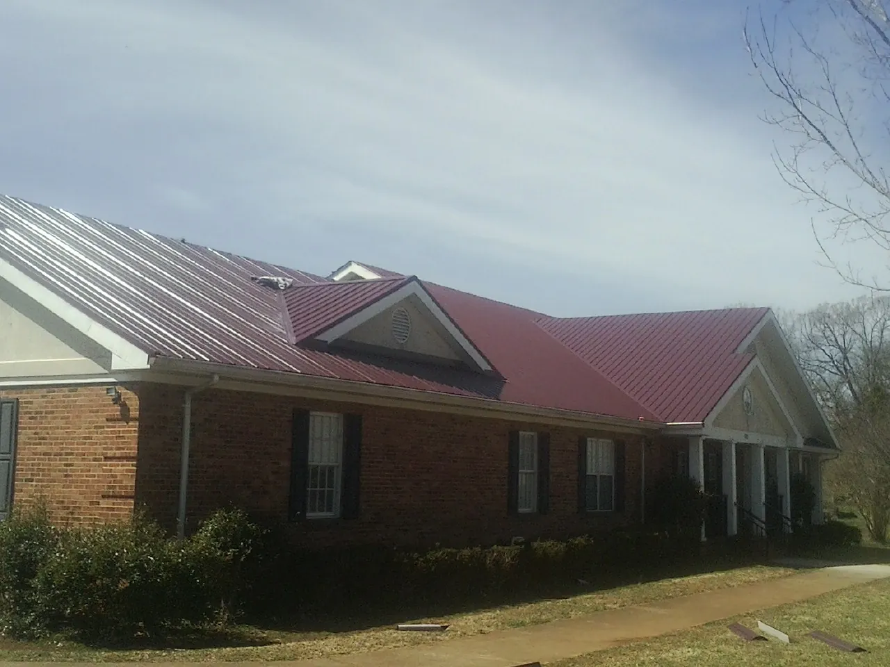 Red metal roof with gabled entries on a long brick building in Fox Island