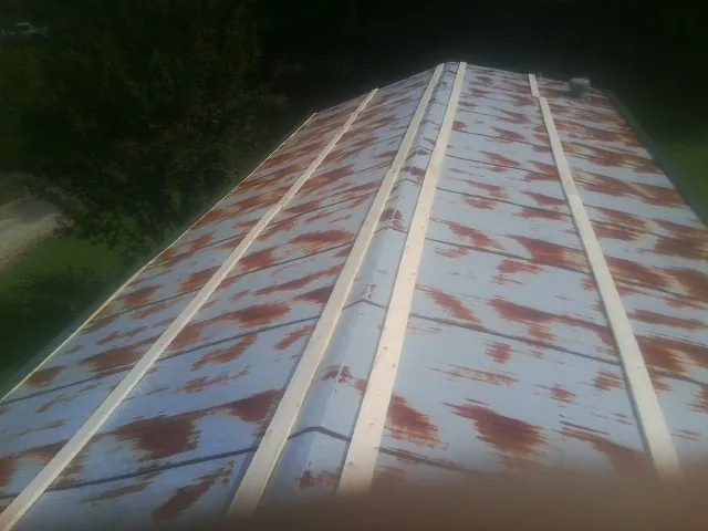 Rusted metal roof panels with new wood purlins before replacement — Storm Damage Roof Repair in Fox Island by Roofing Brothers